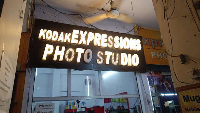 The lit Kodak Expressions Photo Studio sign above the shopfront