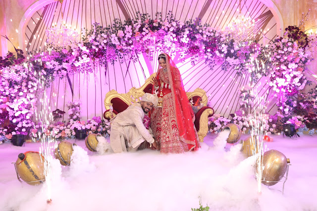 A couple seated on a decorated wedding stage