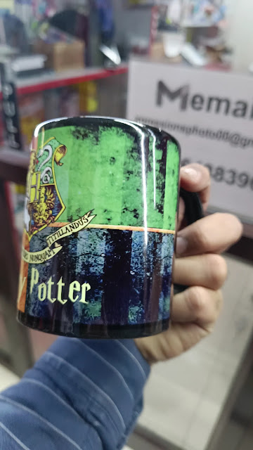 A personalised printed mug held up in the shop